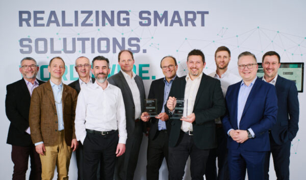 Group photo of the management teams at Diehl Metering and STACKFORCE, illustrating the companies' partnership