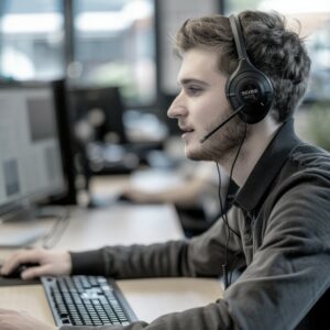 Photo of a support representative with a headset in an office environment, symbolizing customer contact and assistance